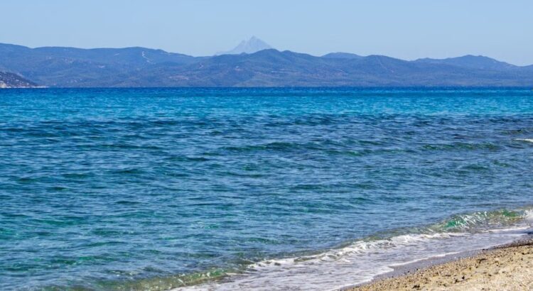 Helder blauw water en een zandstrand aan de kust bij Thessaloniki